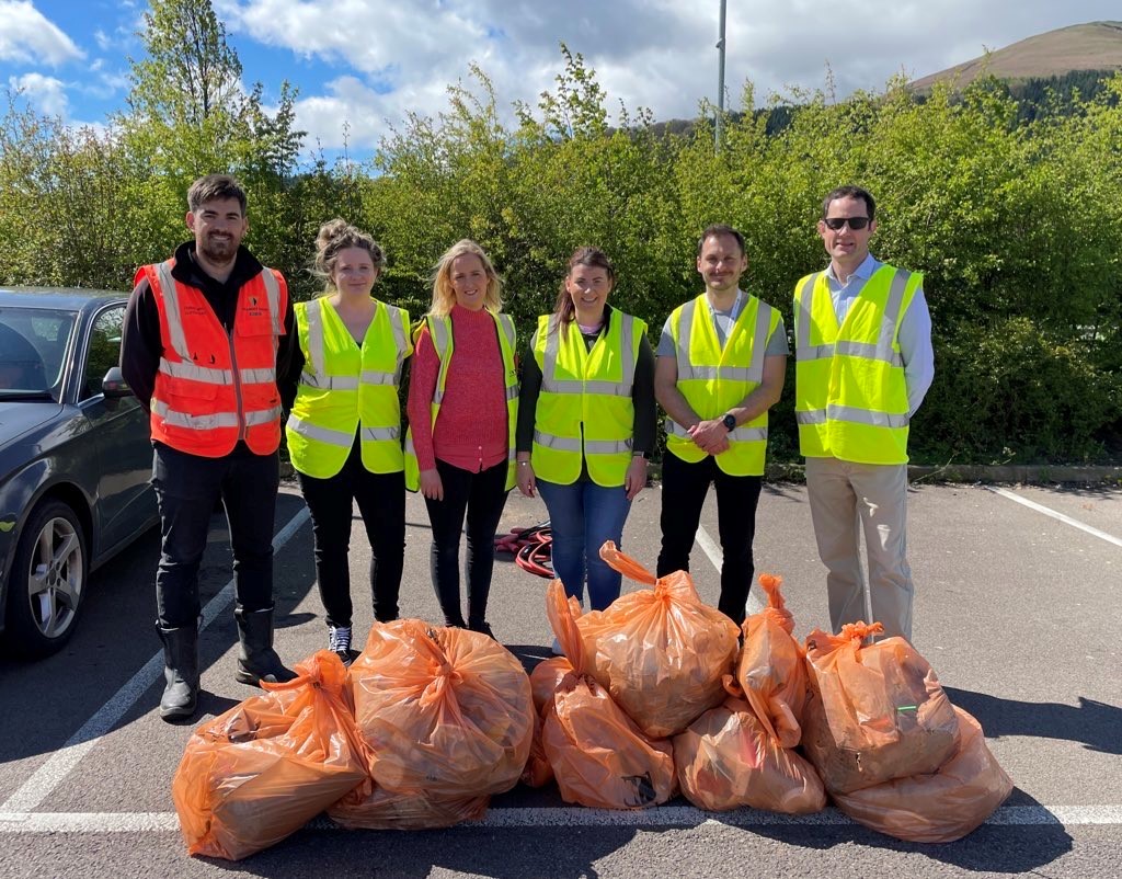 Partners stood in front of rubbish bags