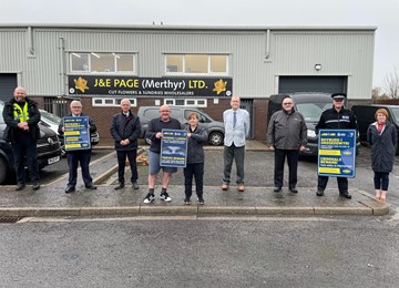 People in room holding we don't buy crime signs