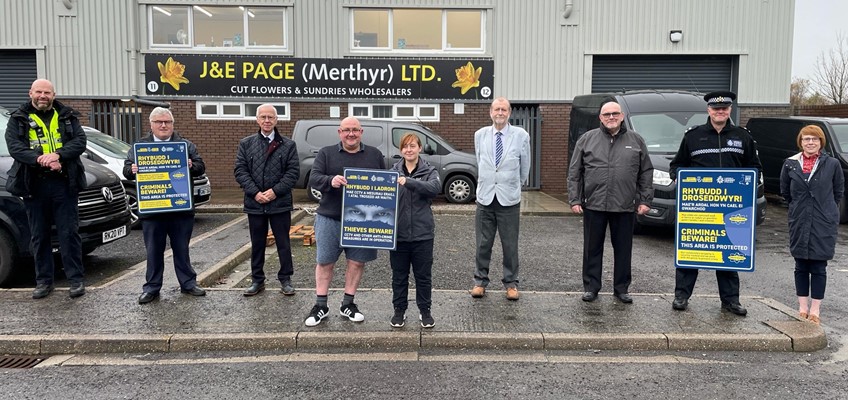 People in room holding we don't buy crime signs