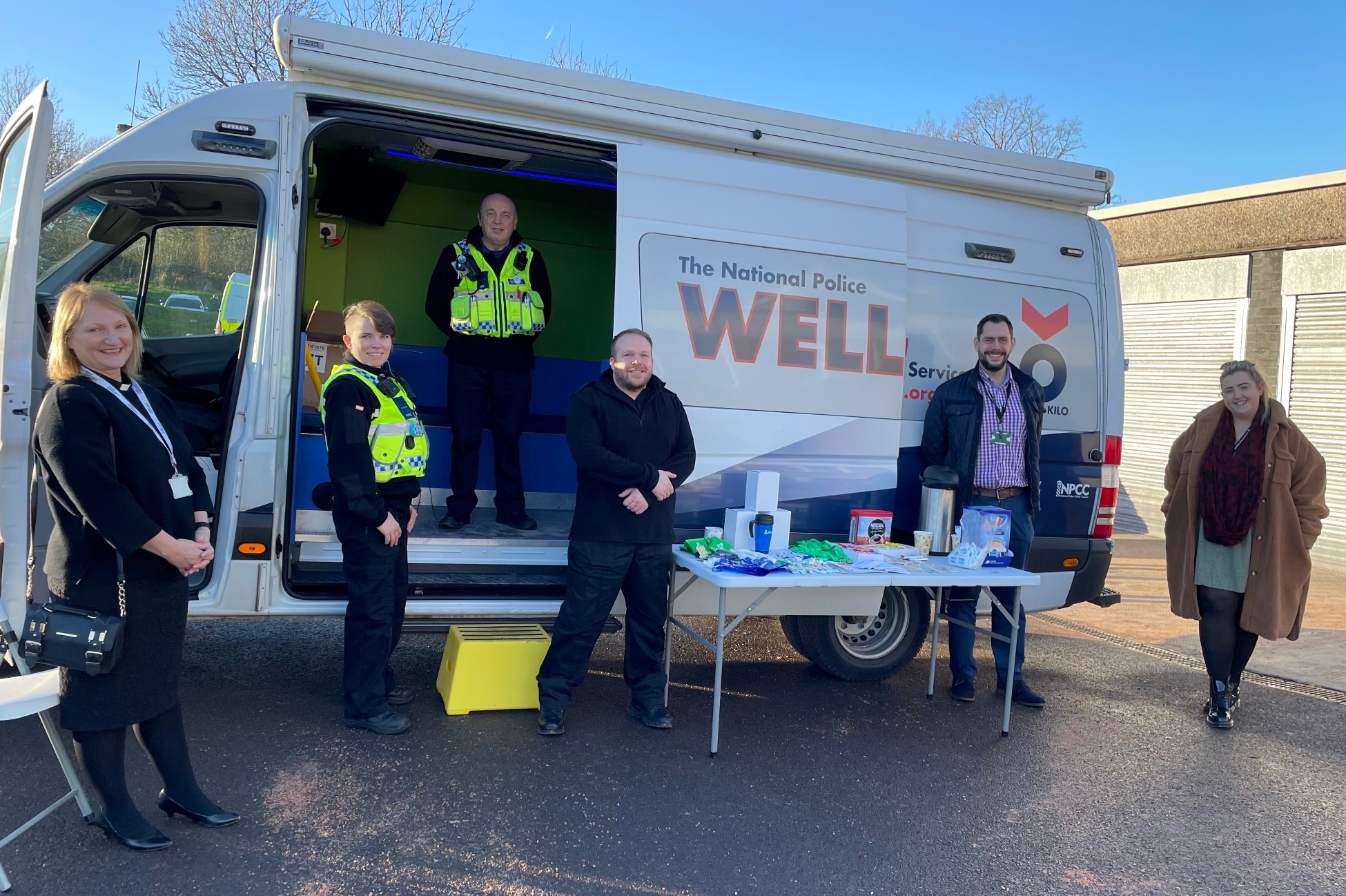 Police officers and support staff outside van