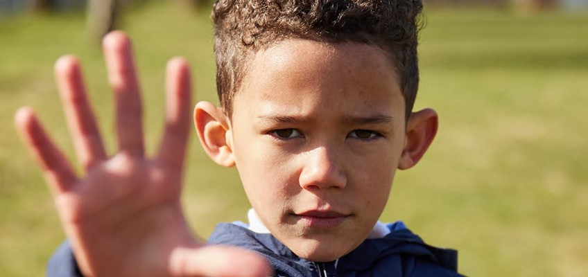boy with hand stretched out indicating STOP