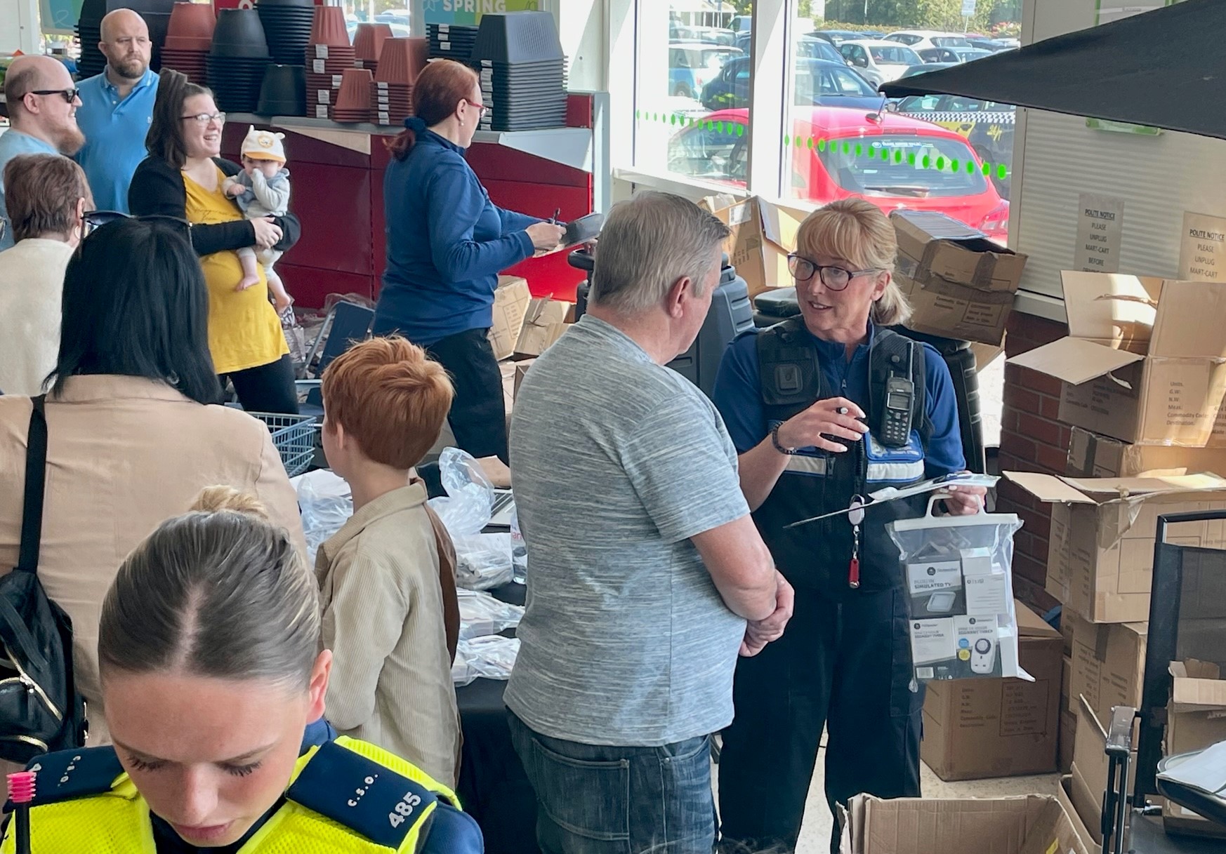 Pobl yn siarad â swyddogion mewn digwyddiad atal troseddu