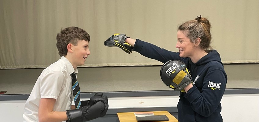 Student boxing with trainer