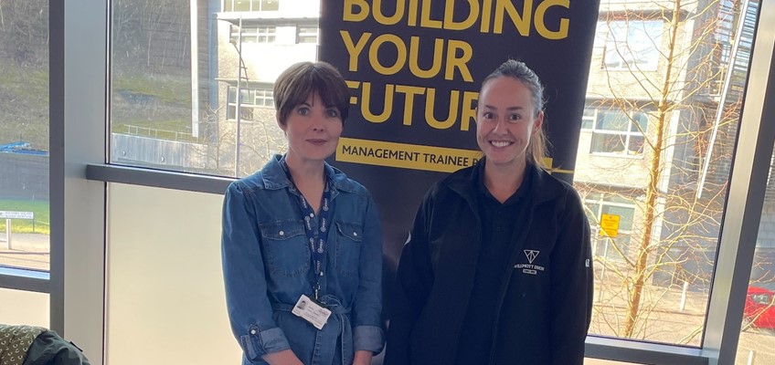 Staff members stood in front of banner