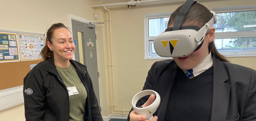 Cynrychiolydd o Willmott Dixon gyda merch yn gwisgo headset VR