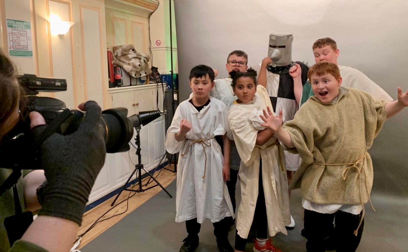 Children dressed as medieval knights being film by someone on camera 