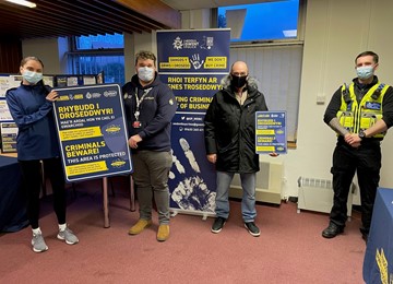 People in room holding we don't buy crime signs