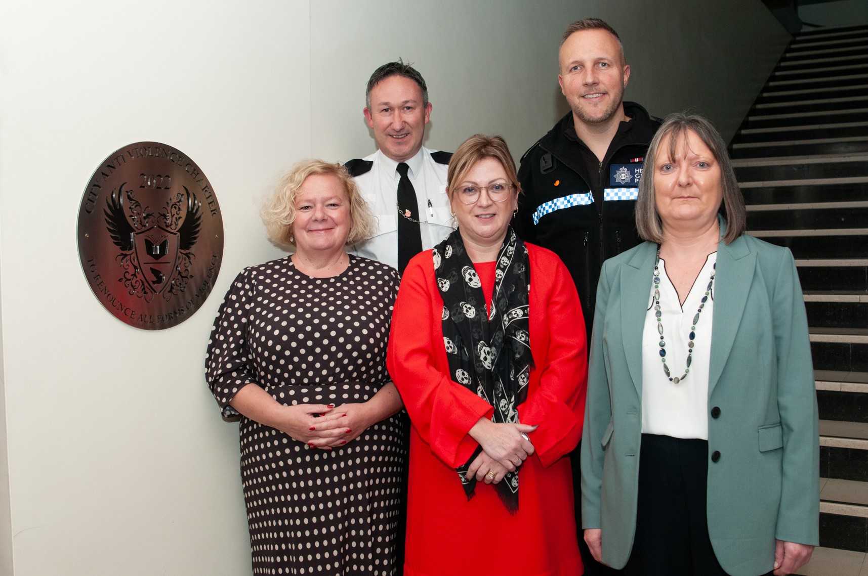 Representatives from partner organisations standing in front of plaque 