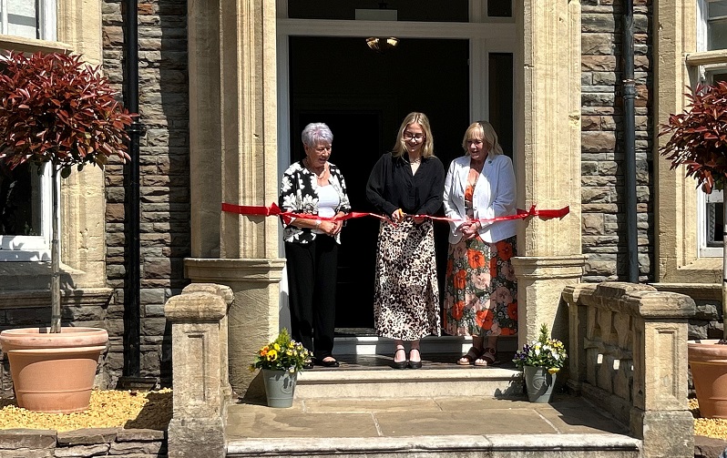 Three people cutting ribbon