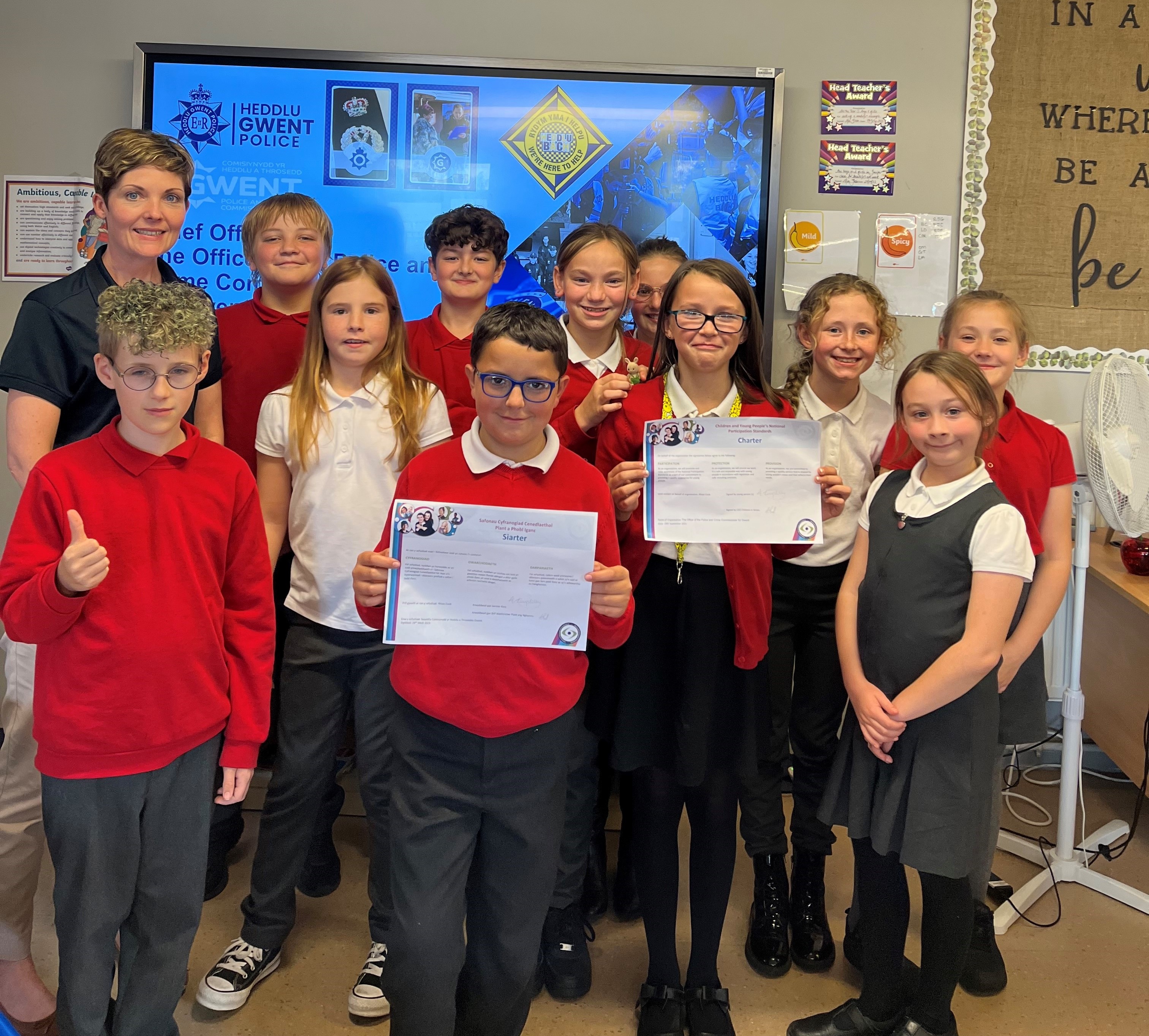 Group of children with the child at the front holding a certificate