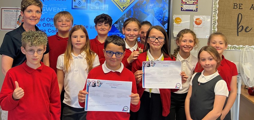 Group of children with the child at the front holding a certificate