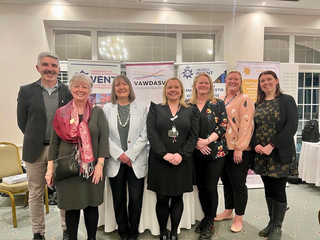 Eleri Thomas a'i phartneriaid o flaen baneri