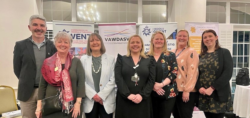 Eleri Thomas a'i phartneriaid o flaen baneri