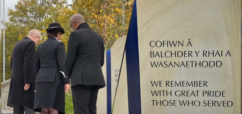 Commissioner, Chief Constable and Pastor with heads bowed towards memorial stone