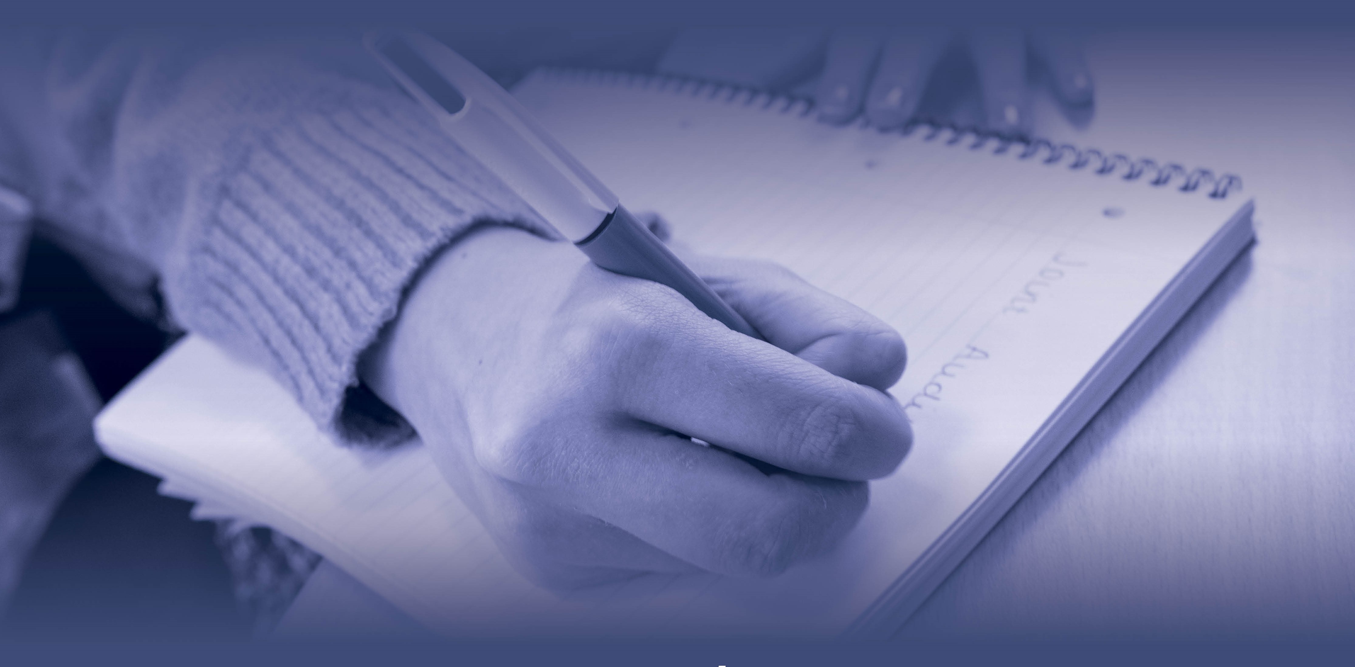 hand with pen writing on note pad