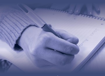 hand with pen writing on note pad